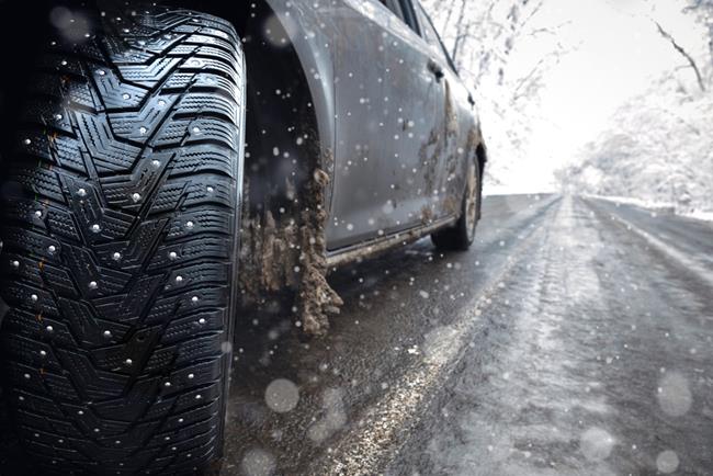 auto na zimowej drodze z zamontowanymi oponami kolcowanymi